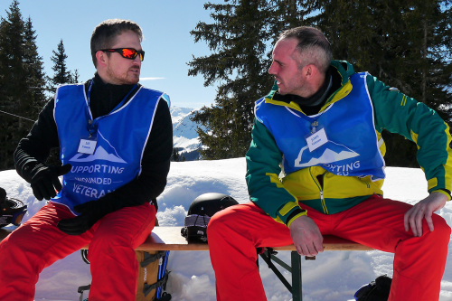 two men talking on a snowy mountain